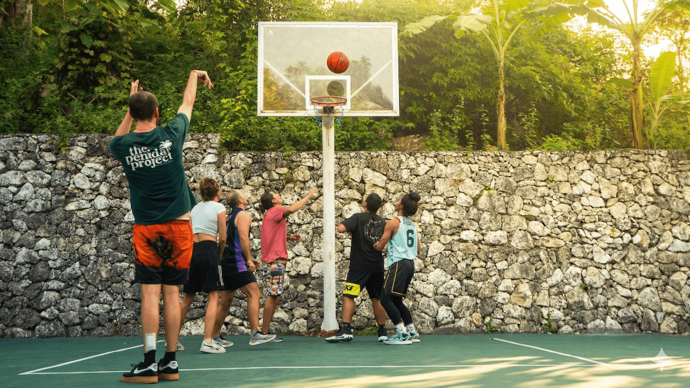 Guests playing basketball on The Penida Project hostel court
