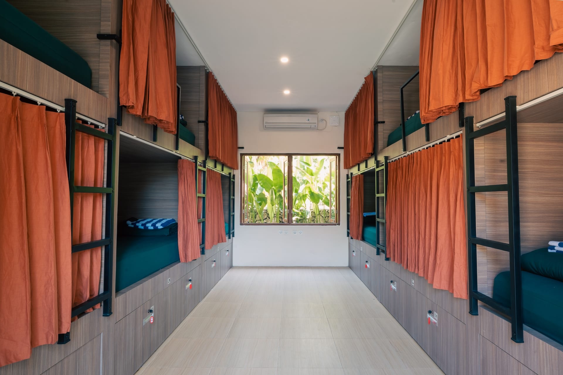 Capsule dorm room with privacy curtains and lockers at The Penida Project in Nusa Penida